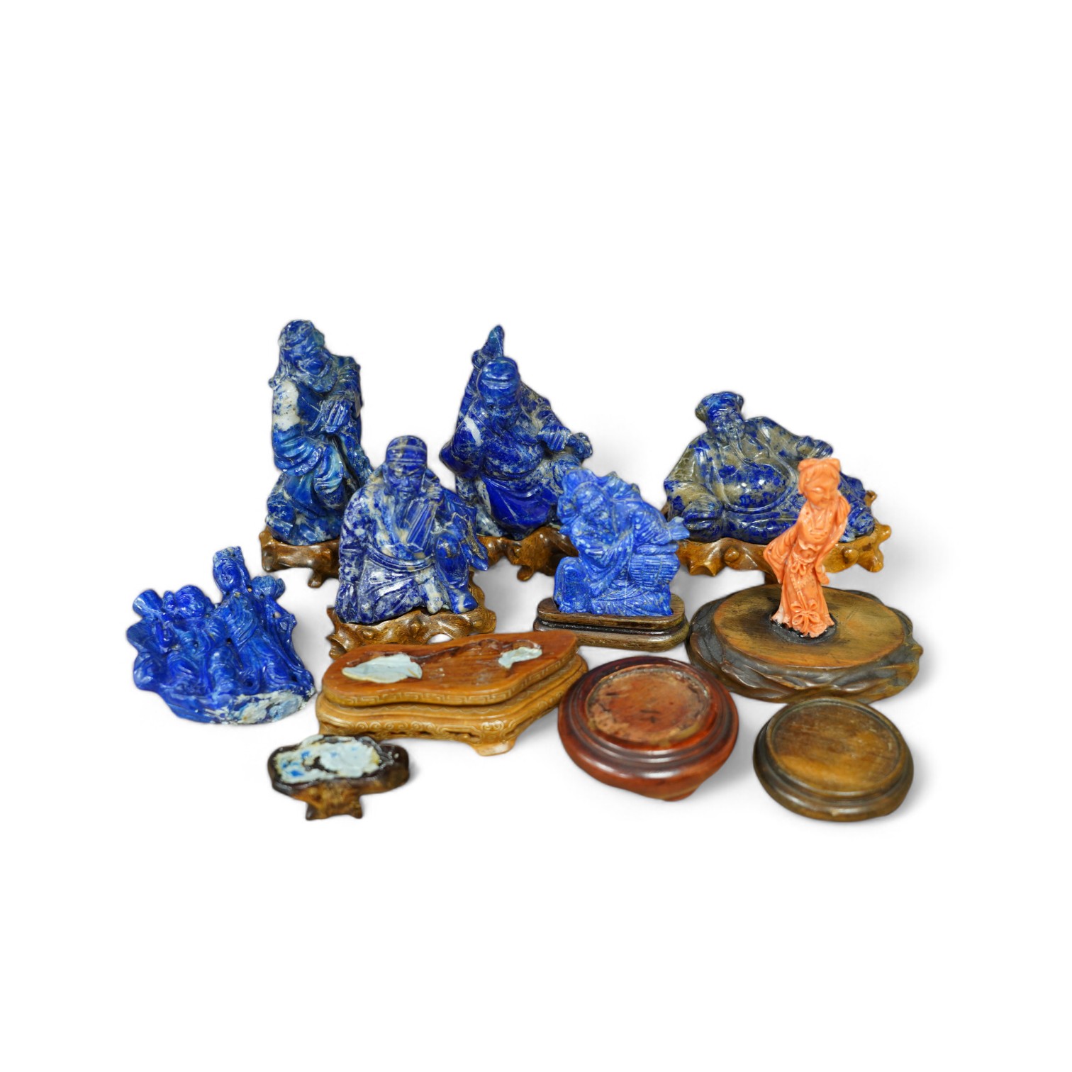 Six Chinese lapis lazuli carvings of immortals, wood stands and a Chinese coral carving of a woman reclining, Buddha on stand 11cm wide (7). Condition - fair